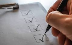 Main cochant des cases sur une checklist papier avec un stylo